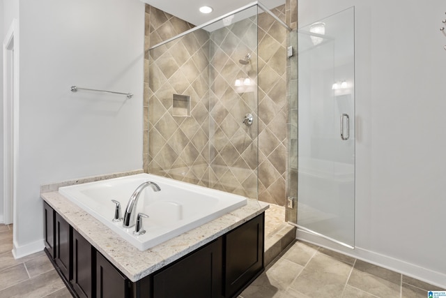 full bathroom featuring baseboards, a shower stall, and a garden tub