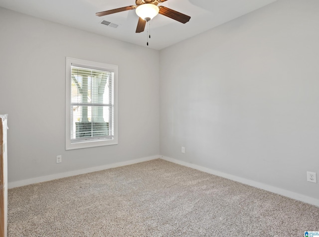 carpeted empty room with visible vents, baseboards, and ceiling fan