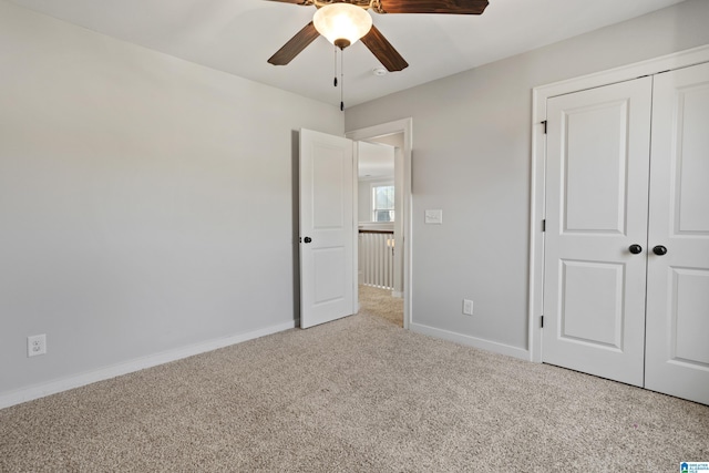 unfurnished bedroom featuring a closet, carpet flooring, baseboards, and a ceiling fan
