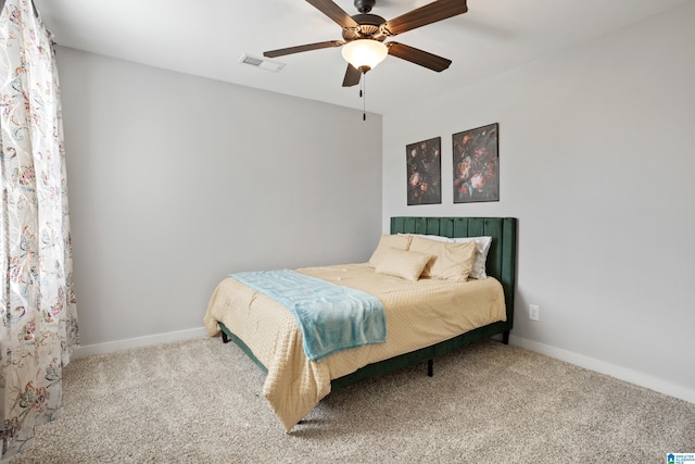 carpeted bedroom with visible vents, baseboards, and ceiling fan