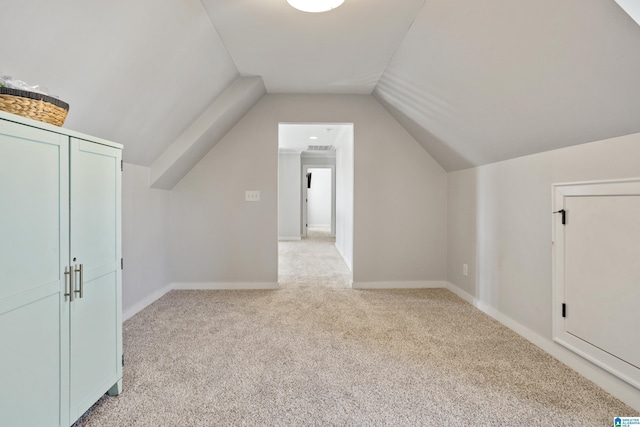 bonus room featuring baseboards, light colored carpet, and vaulted ceiling