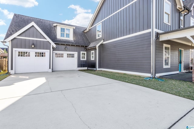 view of front of home with concrete driveway, board and batten siding, a garage, and a shingled roof