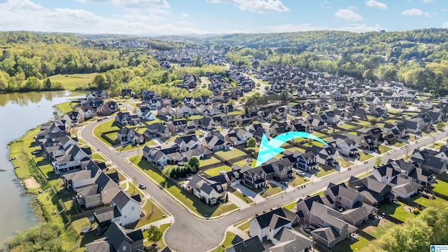 birds eye view of property with a forest view, a residential view, and a water view