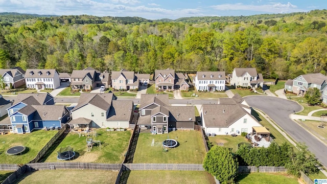 drone / aerial view featuring a view of trees and a residential view