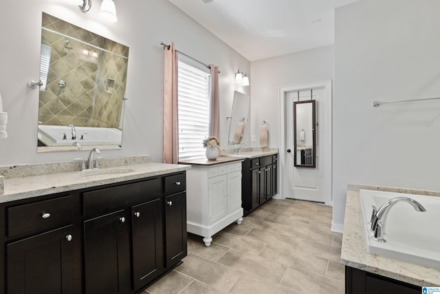 bathroom featuring two vanities, tiled shower, a bathing tub, and a sink
