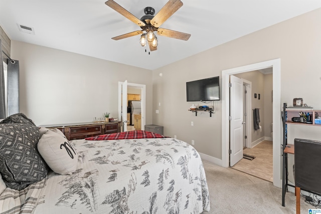 bedroom featuring ceiling fan, freestanding refrigerator, visible vents, light carpet, and baseboards