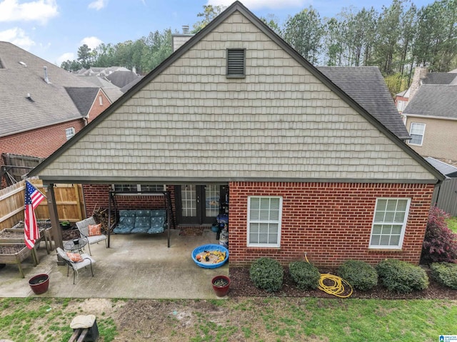 view of side of home featuring a patio, a chimney, and fence