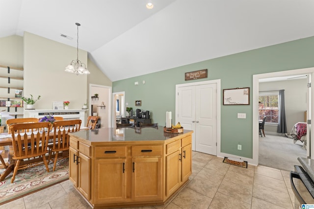 kitchen featuring visible vents, light tile patterned floors, a center island, hanging light fixtures, and vaulted ceiling
