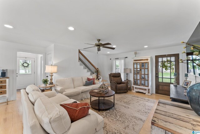 living area with a ceiling fan, light wood-style flooring, stairs, and recessed lighting