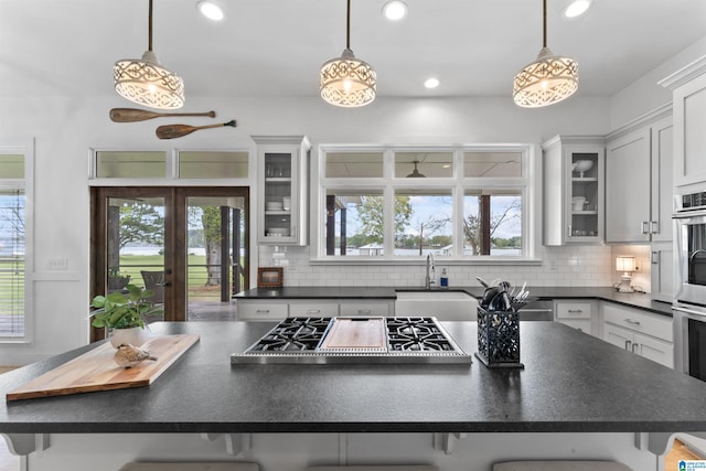 kitchen with a center island, a sink, dark countertops, and appliances with stainless steel finishes