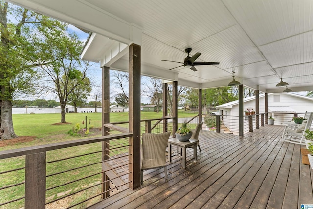 wooden terrace with a lawn, a water view, and ceiling fan