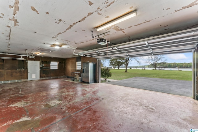 garage featuring a garage door opener and stainless steel fridge