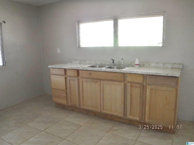 bathroom with tile patterned flooring, a sink, and a wealth of natural light
