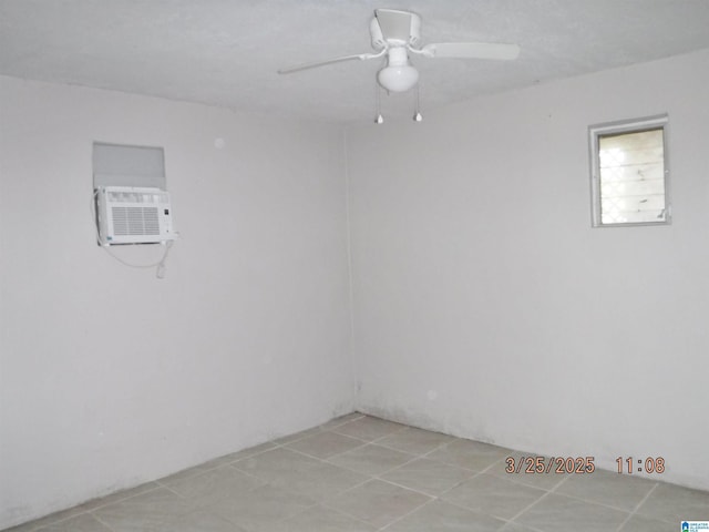 empty room featuring a wall unit AC, light tile patterned floors, and a ceiling fan
