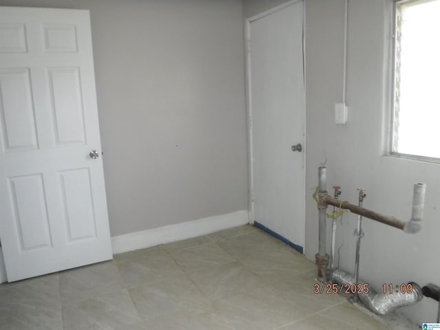 laundry room featuring light tile patterned floors, baseboards, and laundry area