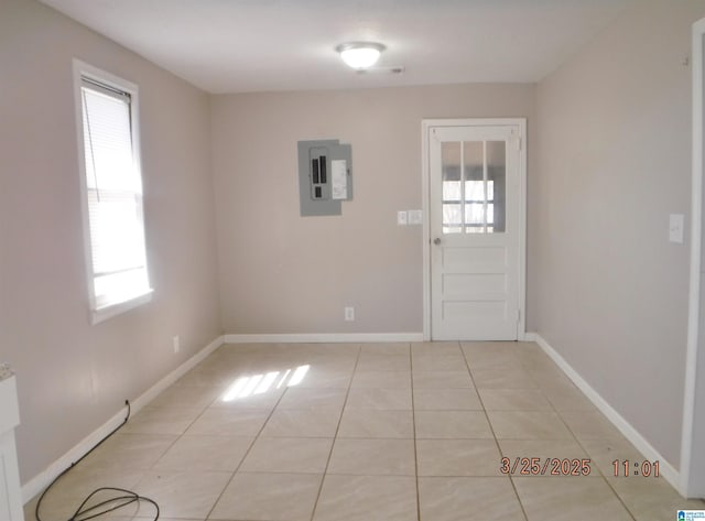 foyer entrance featuring electric panel, baseboards, and light tile patterned floors