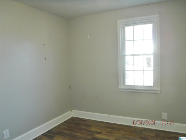 unfurnished room with dark wood-type flooring and baseboards