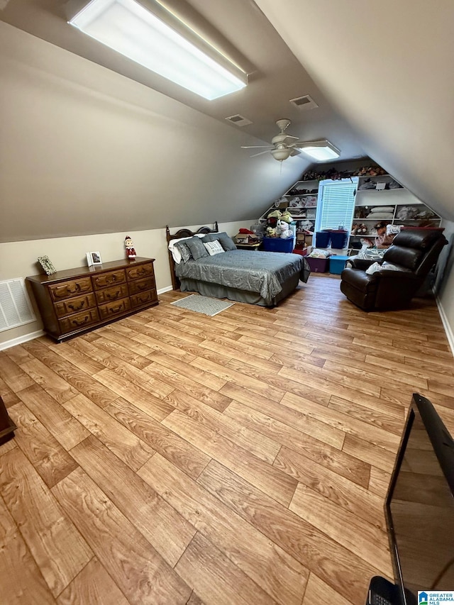 unfurnished bedroom featuring ceiling fan, vaulted ceiling, light wood finished floors, and visible vents