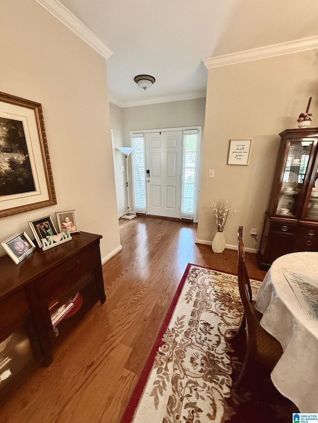 entryway featuring baseboards, ornamental molding, and wood finished floors