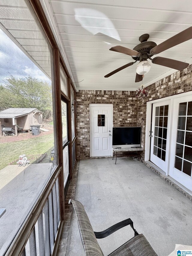 unfurnished sunroom featuring a ceiling fan