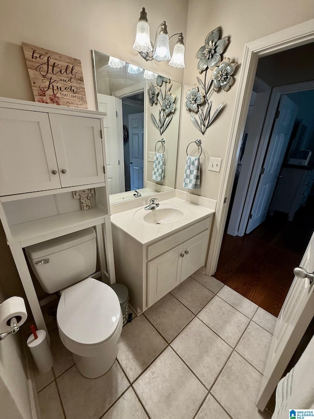 bathroom featuring toilet, tile patterned flooring, and vanity