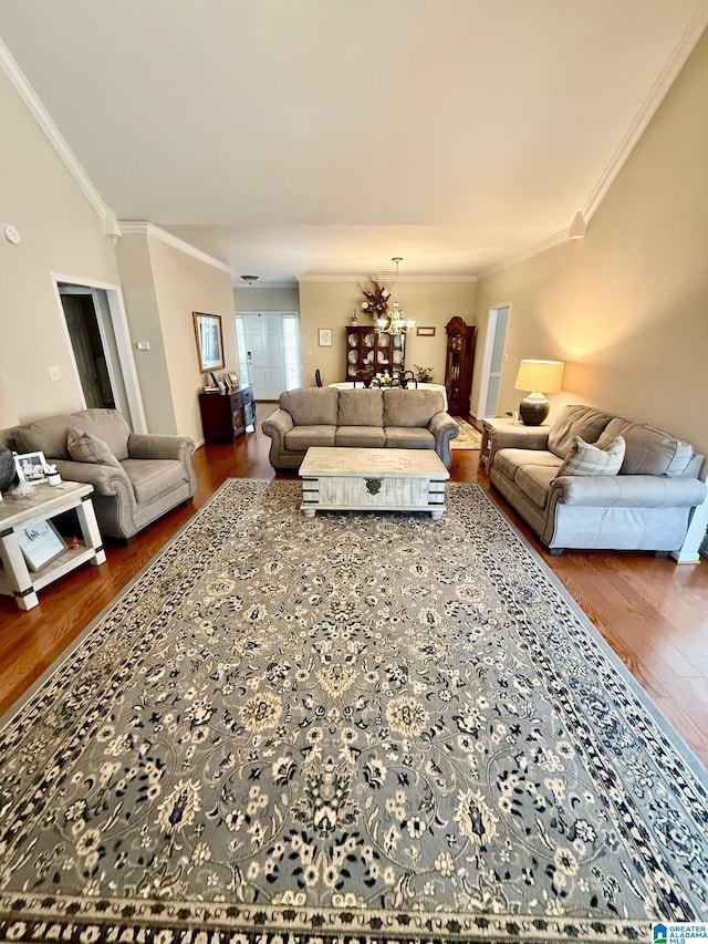 living area featuring wood finished floors, ornamental molding, and an inviting chandelier