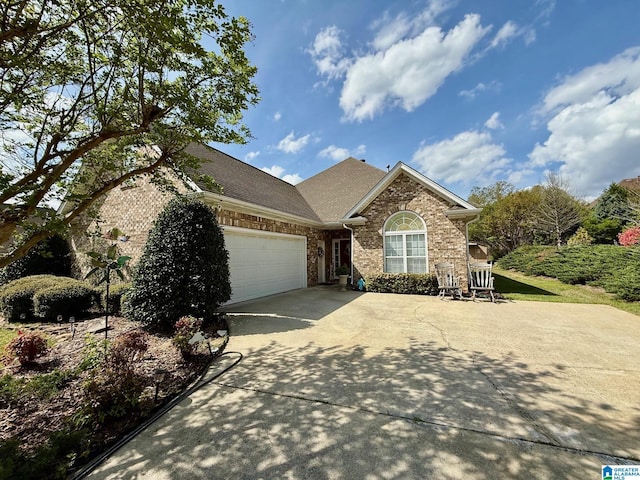 single story home featuring roof with shingles, a garage, brick siding, and concrete driveway