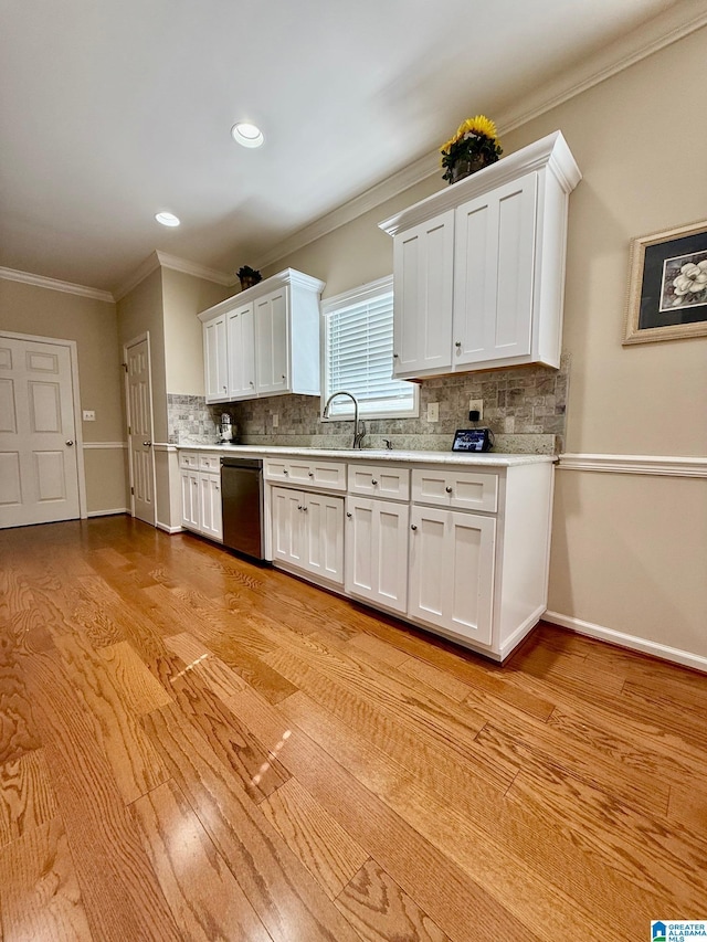 kitchen with dishwasher, light countertops, white cabinetry, and backsplash