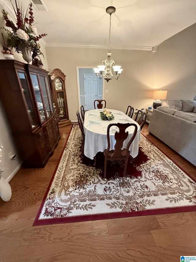 dining area with baseboards, ornamental molding, visible vents, and a chandelier