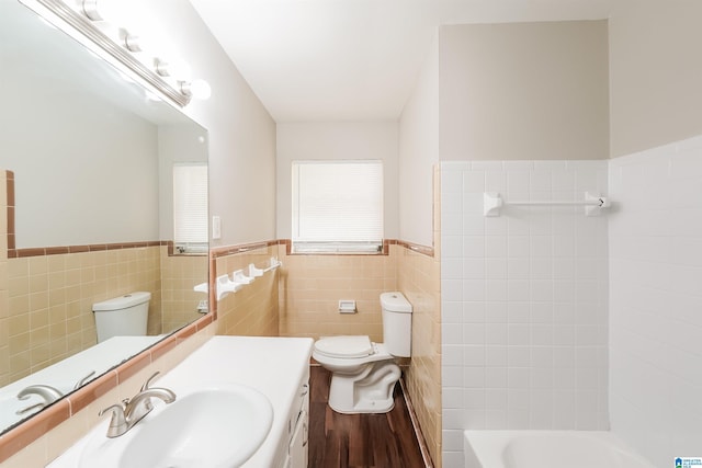 1625 Mann Dr, Birmingham, AL 35214 - bathroom featuring vanity, tile walls, toilet, a wainscoted wall, and wood finished floors