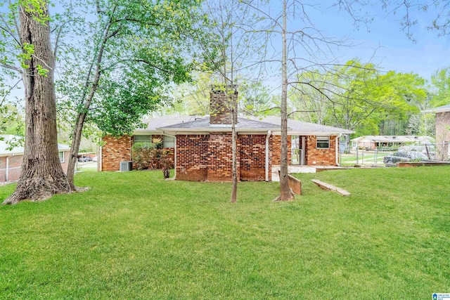 1625 Mann Dr, Birmingham, AL 35214 - rear view of house with a chimney, brick siding, and a lawn
