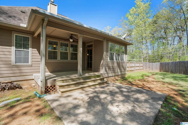 13147 Allison Dr, Lake View, AL 35111 - view of exterior entry featuring ceiling fan, roof with shingles, a patio area, fence, and a chimney