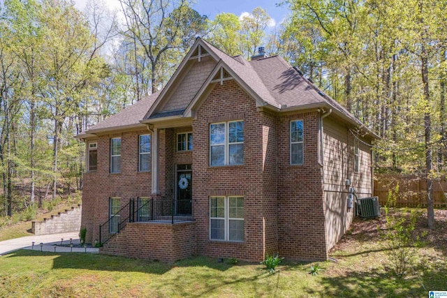 13147 Allison Dr, Lake View, AL 35111 - view of front facade featuring roof with shingles, cooling unit, a front lawn, brick siding, and fence
