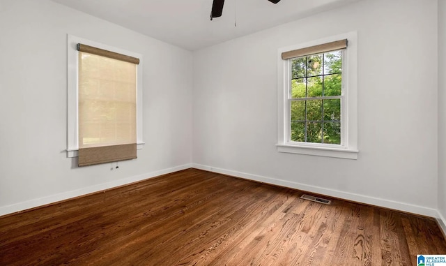 empty room featuring visible vents, baseboards, a ceiling fan, and wood finished floors