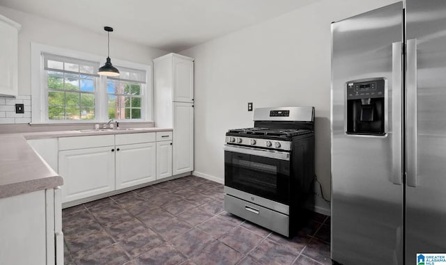 kitchen featuring white cabinets, decorative light fixtures, a sink, light countertops, and stainless steel appliances