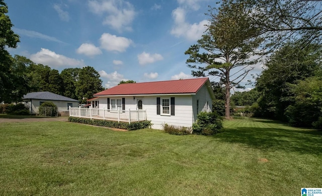 back of house featuring a wooden deck, metal roof, and a lawn