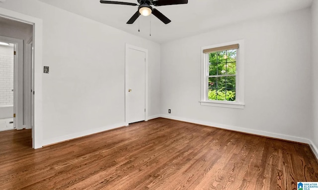 spare room with ceiling fan, baseboards, and wood finished floors