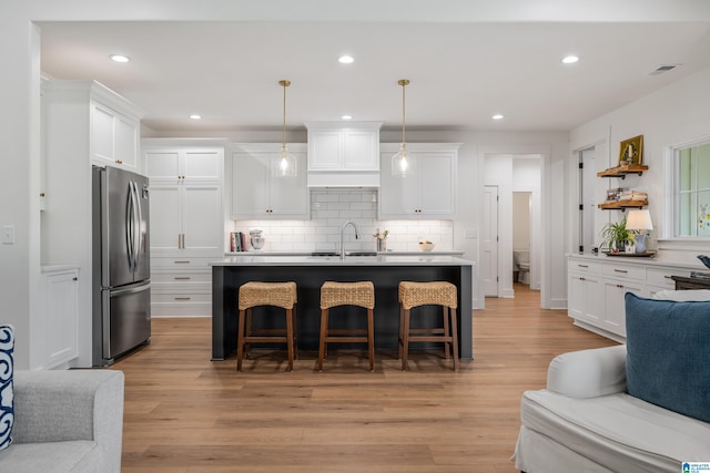 2505 Shore Side Ln, Sylacauga, AL 35151 - kitchen with freestanding refrigerator, visible vents, a breakfast bar, a sink, and open floor plan