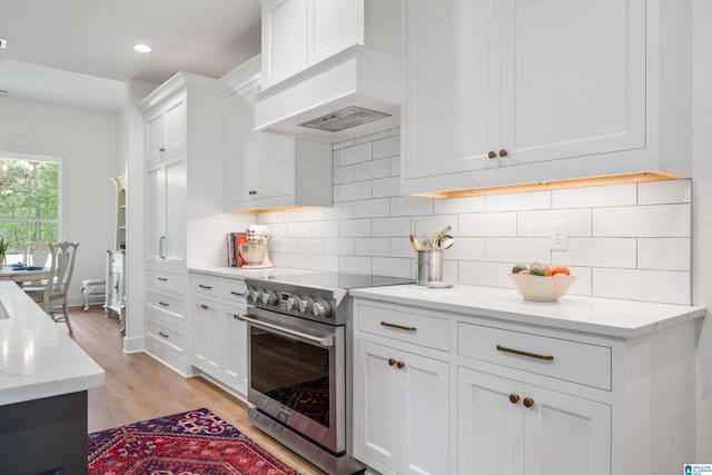 2505 Shore Side Ln, Sylacauga, AL 35151 - kitchen with tasteful backsplash, white cabinets, stainless steel stove, and premium range hood