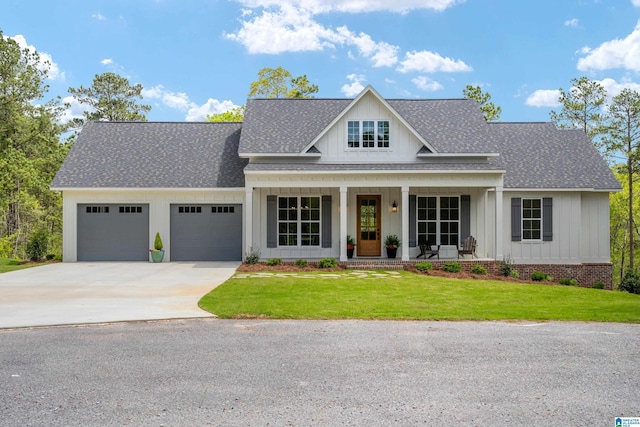 2505 Shore Side Ln, Sylacauga, AL 35151 - view of front of house featuring driveway, a front lawn, an attached garage, a shingled roof, and covered porch