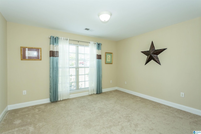 unfurnished room featuring carpet flooring, visible vents, and baseboards