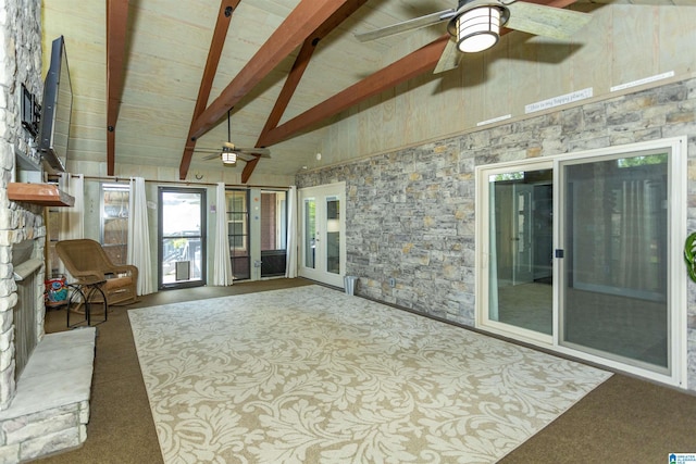 unfurnished sunroom featuring beam ceiling, high vaulted ceiling, and carpet floors
