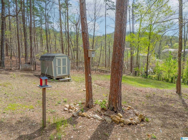 910 12th Ave NE, Jacksonville, AL 36265 - view of yard with an outbuilding, a shed, and a forest view