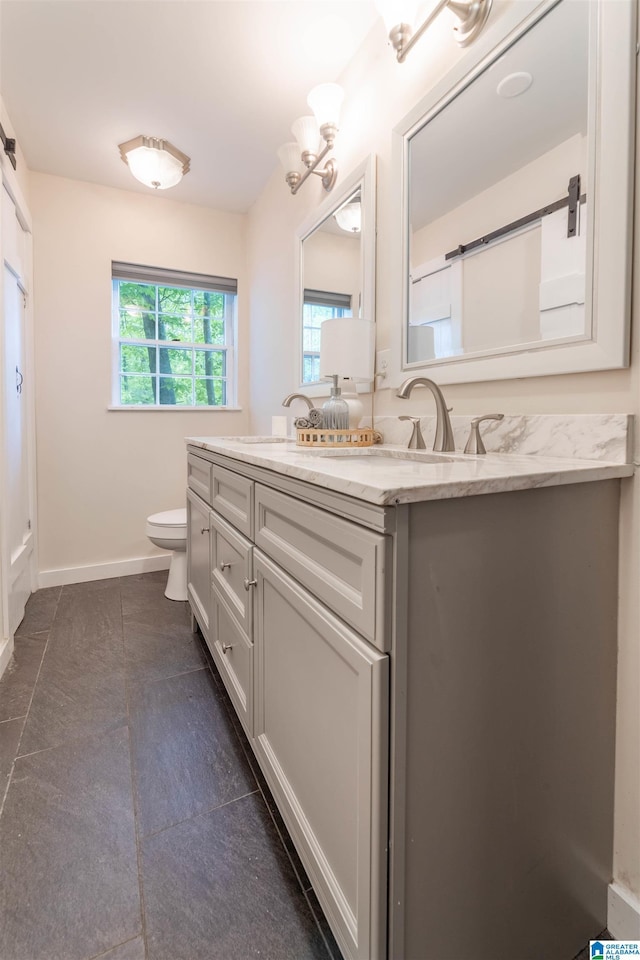 910 12th Ave NE, Jacksonville, AL 36265 - full bathroom with baseboards, toilet, tile patterned flooring, and vanity