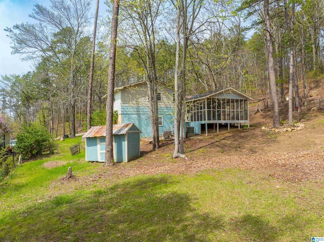 910 12th Ave NE, Jacksonville, AL 36265 - exterior space featuring an outdoor structure, a sunroom, cooling unit, and a shed