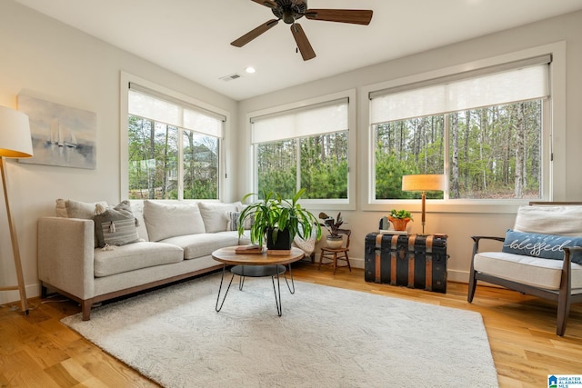 living room featuring light wood-style floors, ceiling fan, visible vents, and recessed lighting