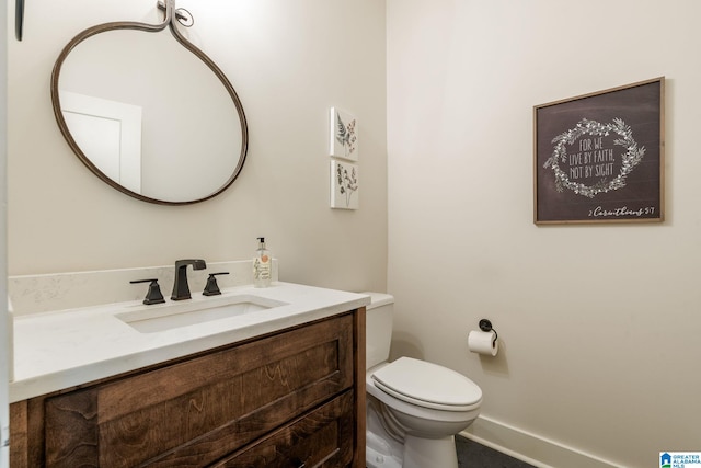 bathroom featuring vanity, baseboards, and toilet