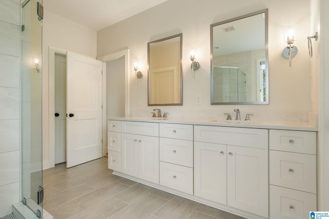 full bathroom with a sink, double vanity, and a stall shower