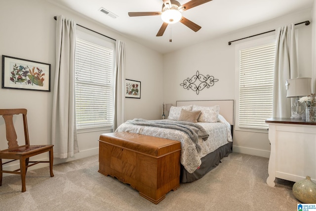 bedroom with light carpet, ceiling fan, baseboards, and visible vents