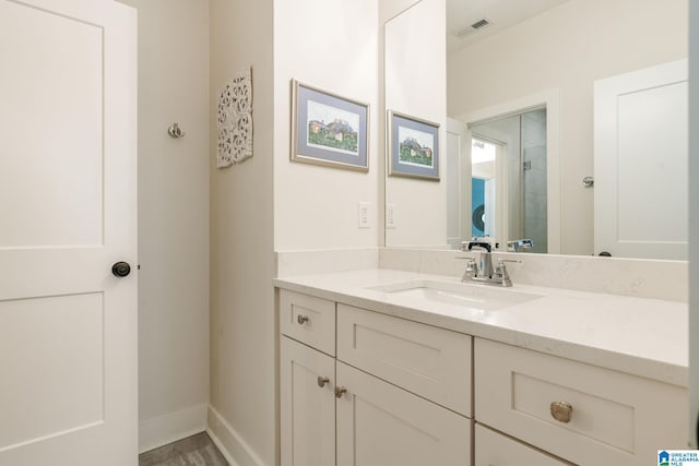bathroom with vanity, visible vents, and baseboards